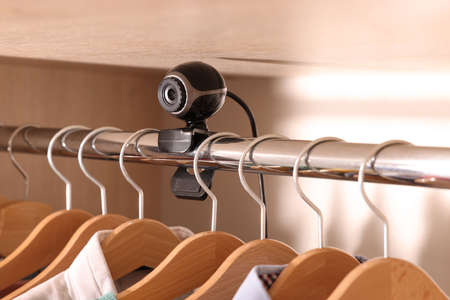 Camera hidden between hangers in wardrobe closet
