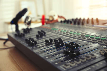 Professional mixing console on table in modern radio studio, closeup