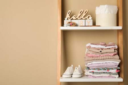 Baby clothes and accessories on wooden rack, space for textの写真素材