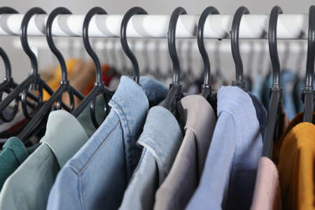 Rack with stylish clothes on blurred background, closeup. fast fashion