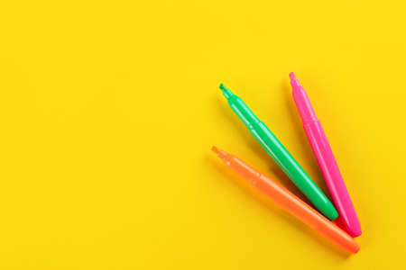 Colorful markers on yellow background, flat lay. Space for textの写真素材