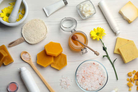 Flat lay composition with beeswax and cosmetic products on white wooden tableの写真素材