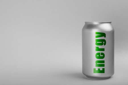 Can of energy drink on light gray background. Space for text