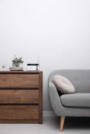 Stylish white radio on wooden cabinet in living room interior. Space for textの写真素材