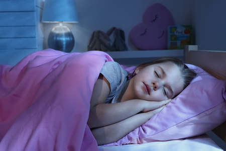 Cute little girl sleeping in bed at home