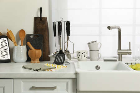 Countertop with sink and cooking utensils in kitchen