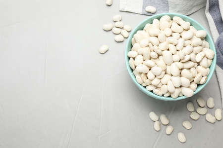Raw white beans on light gray table, flat lay. Space for textの写真素材