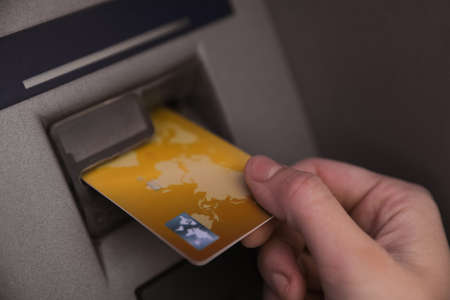Woman inserting credit card into cash machine, closeupの写真素材