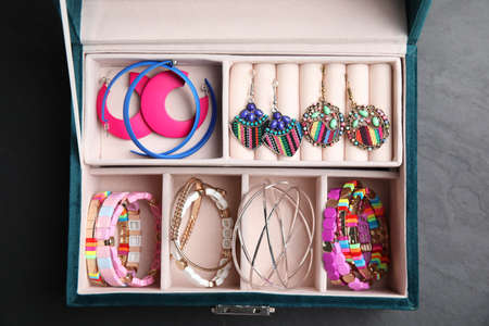 Elegant jewelry box with beautiful bijouterie on gray table, top view