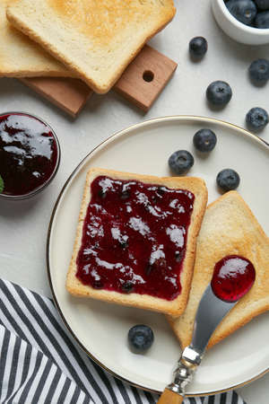 Toasts served with blueberry jam on light table, flat layの写真素材