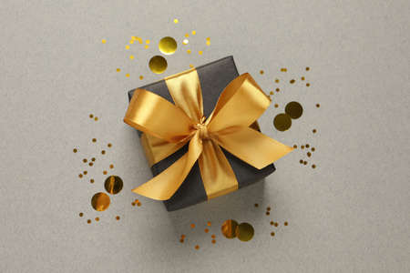 Beautiful gift box and confetti on gray background, flat layの写真素材