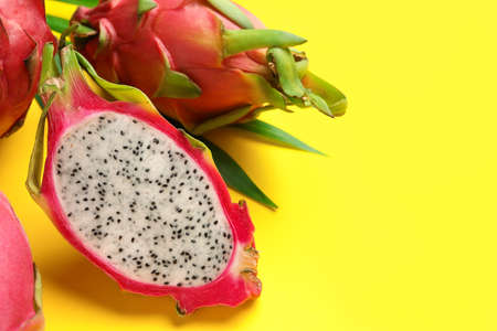 Delicious cut and whole white pitahaya fruits on yellow background. Space for textの写真素材