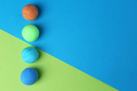 Different bright play dough on color background, flat lay. Space for textの写真素材