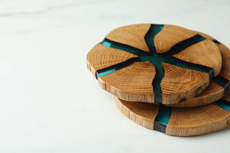 Stylish wooden cup coasters on white marble table, space for textの写真素材