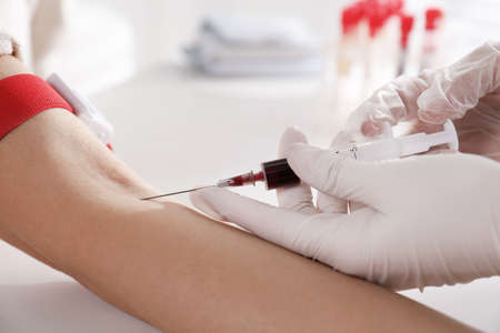Nurse drawing blood sample from patient in clinic, closeupの写真素材