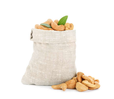 Sack, tasty organic cashew nuts and green leaves isolated on whiteの写真素材