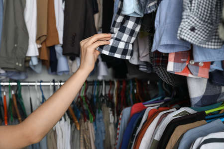 Woman picking clothes from rack, closeup. fast fashion