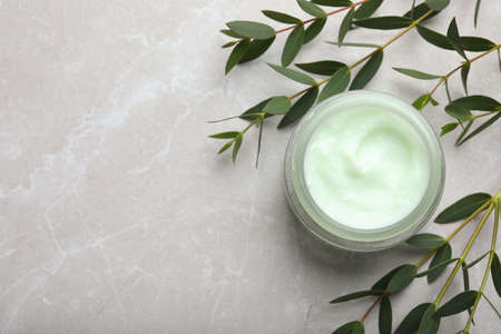 Jar of organic cream and eucalyptus on light marble table, flat lay. Space for textの写真素材
