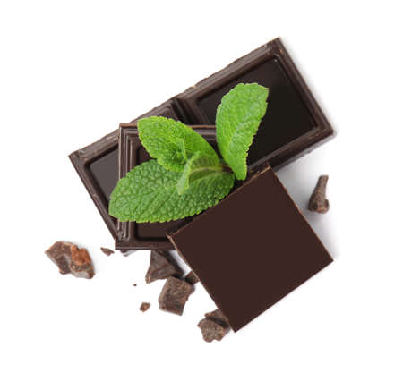 Tasty dark chocolate pieces with mint on white background, top viewの写真素材