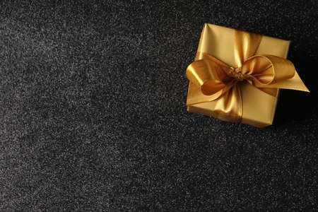 Beautifully wrapped gift box on black background, top view. Space for textの写真素材