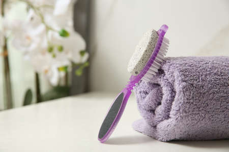 Pedicure tool with pumice stone and foot file near towel on white table, closeup. Space for textの写真素材