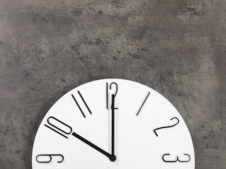 Stylish analog clock hanging on gray wall, space for textの写真素材
