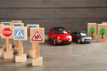 Many different miniature road signs and cars on gray table, space for text. driving schoolの写真素材