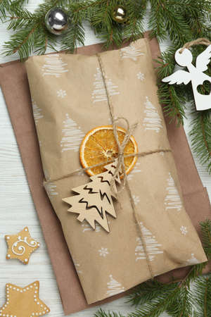 Wrapped Christmas Stollen with decoration on white wooden table, flat lay