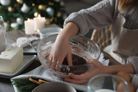 Little child making Christmas pastry at wooden table, closeupの写真素材