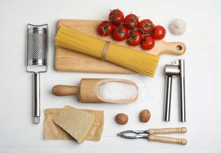 Cooking utensils and ingredients on white wooden table, flat lay