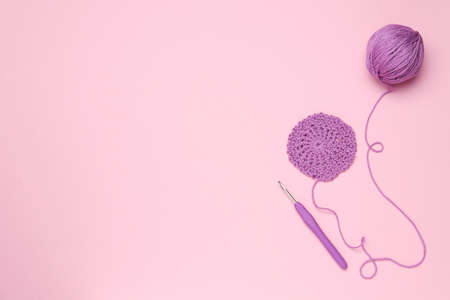 Knitting and crochet hook on pink background, flat lay. Space for textの写真素材