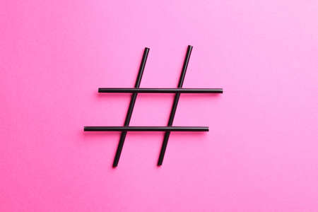Hashtag symbol made of drinking straws on pink background, top viewの写真素材