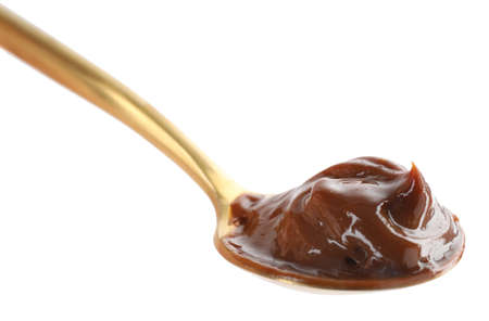 Spoon with tasty boiled condensed milk isolated on whiteの写真素材