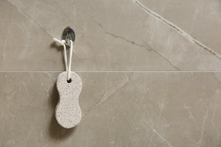 Pumice stone hanging on gray wall, space for textの写真素材