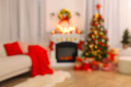 Blurred view of festively decorated room with Christmas tree, fireplace and sofa. interior designの写真素材