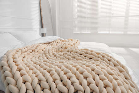 Soft chunky knit blanket on bed indoorsの写真素材