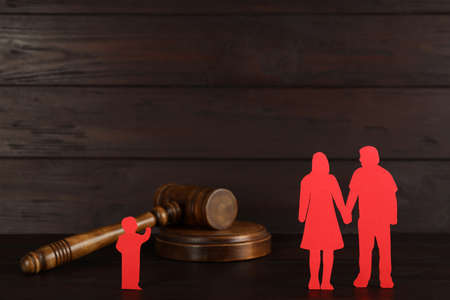 Gavel, paper figures of couple and lonely kid on wooden table. child adoption conceptの写真素材