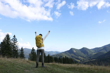 Triumphant tourist on top of mountain, back view. Space for textの写真素材