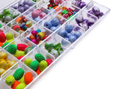 Plastic organizer with different beads on white background. Space for text