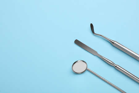 Set of different dentist's tools on light blue background, flat lay. Space for textの写真素材