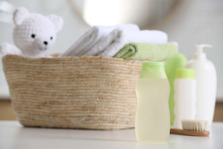 Baby cosmetic products, toy and towels on white table, space for text