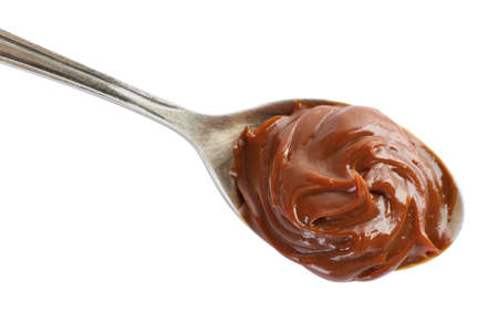 Spoon with tasty boiled condensed milk isolated on white, top viewの写真素材