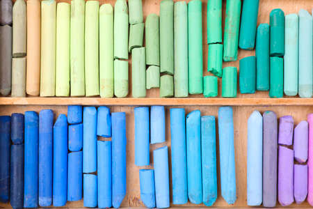Set of soft pastels in wooden box as background, top view. drawing material