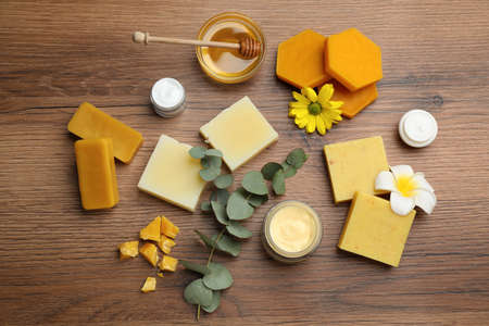 Flat lay composition with beeswax and cosmetic products on wooden tableの写真素材