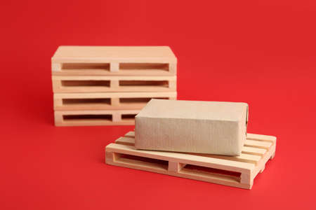 Wooden pallets and boxes on red background
