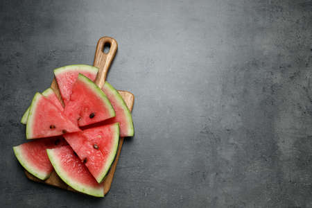 Slices of tasty ripe watermelon on gray table, top view. Space for text