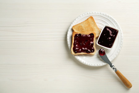 Delicious toasts with jam served on white wooden table, top view. Space for textの写真素材