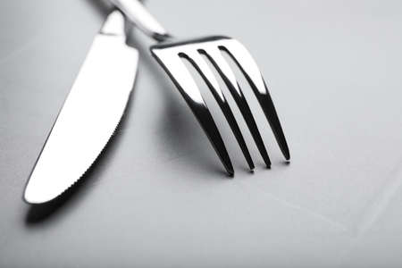 Shiny fork and knife on gray table, closeupの写真素材