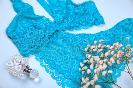 Elegant blue women's underwear, perfume and gypsophila flowers on light background, closeupの写真素材