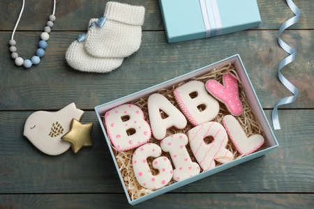 baby shower party. Flat lay composition with open gift box and cookies on light blue wooden backgroundの写真素材